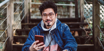 portrait d'un jeune homme qui sourit avec son téléphone