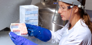 une femme avec un masque porte les flacons de spermatozoïdes