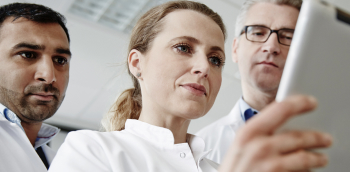 Trois médecins regardent une tablette