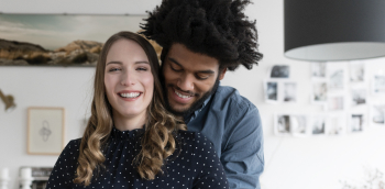 un couple sourit en s'enlaçant
