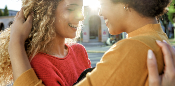 deux femmes se font un câlin en souriant