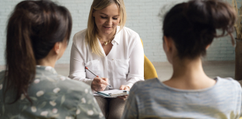 consultation entre un médecin et deux femmes