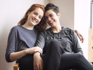 Un couple de femmes passe un moment affectueux. Elles sourient.